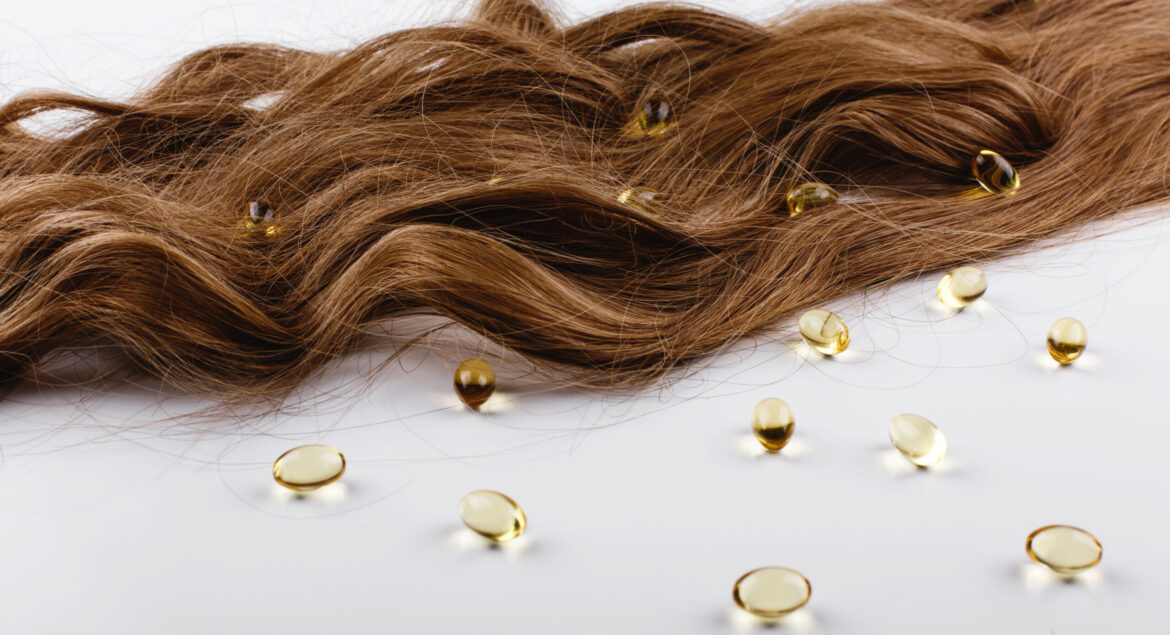 Oil capsules with viatamin E lie on brown hair curls